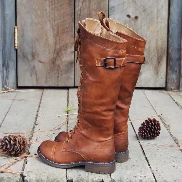 Black women's high-leg boot with a chunky low heel and round toe on a plain background.