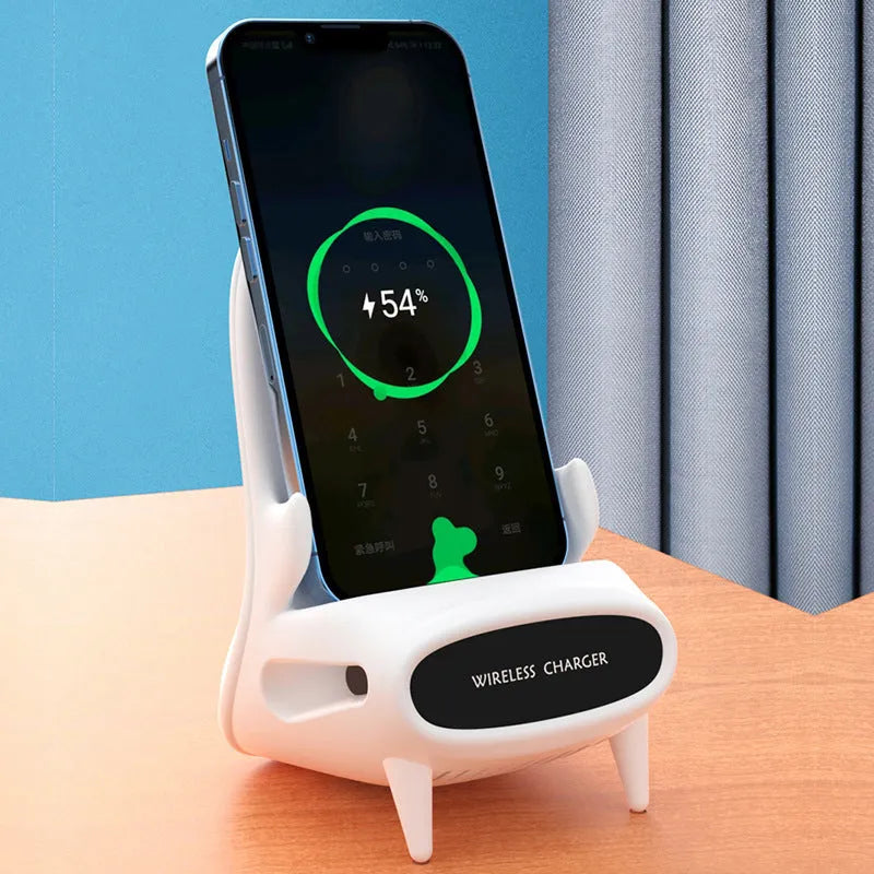 White mini chair-shaped wireless phone charger on a desk, with phone seated on it.