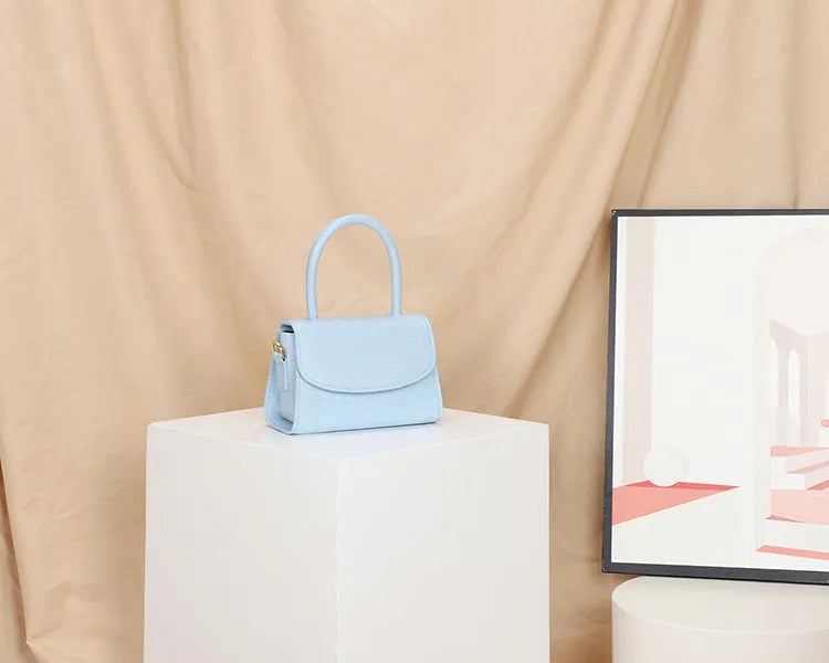 Leather handbag with hard handle, horizontal square shape, 17.5 cm x 7 cm x 11 cm, cover type, in black, blue or light green.
