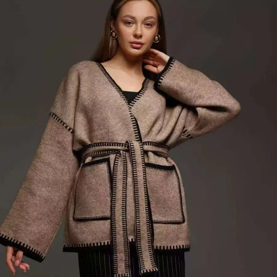 Lace-up front knitted cardigan in a camel colour, shown loose and open over a top.