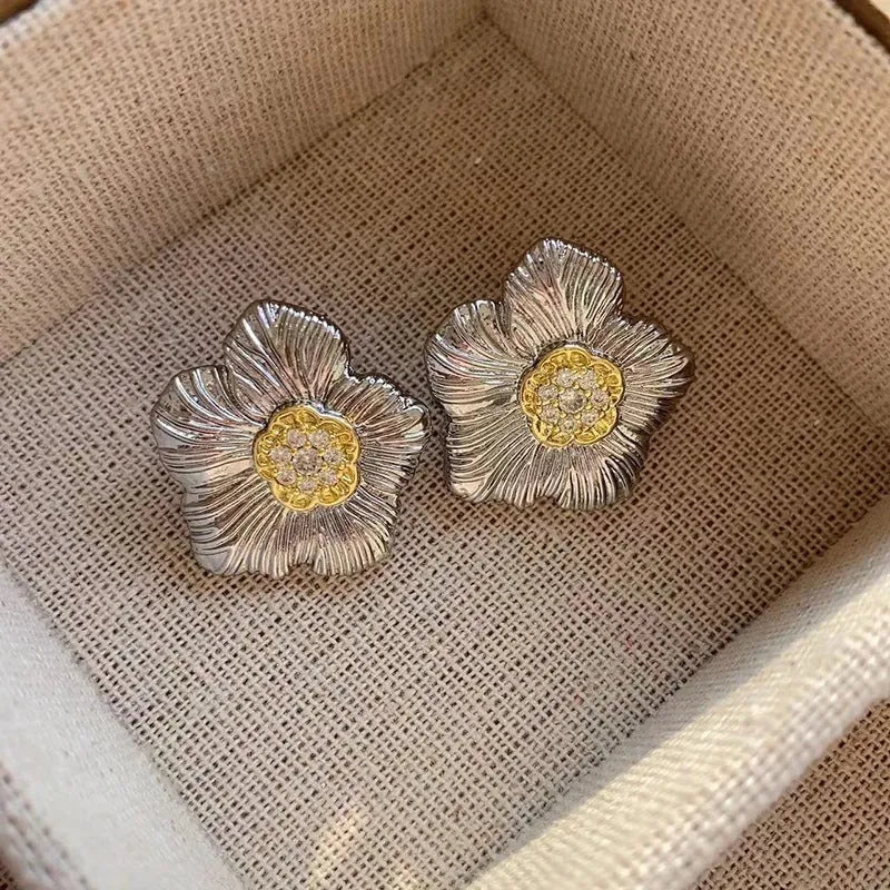 Retro copper stud earrings with a textured gardenia design in a two-tone electroplated finish.