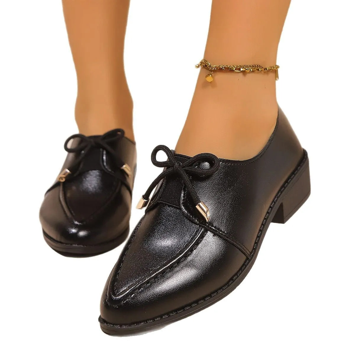 Women's simple leather-look shoes with a decorative bow, on a rubber sole.