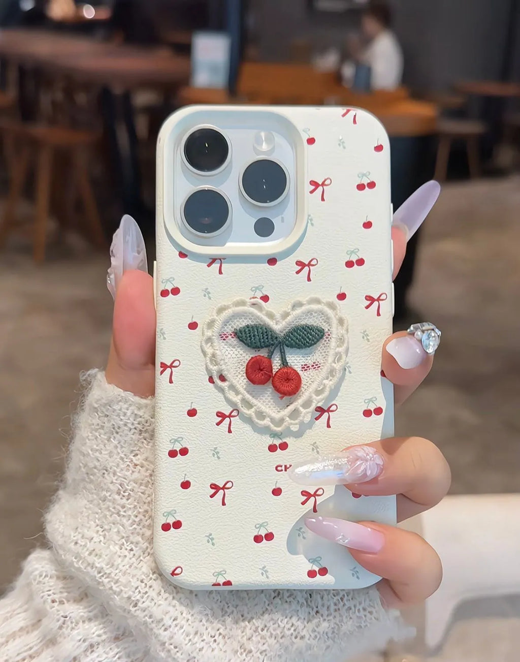 White lychee pattern iPhone case with three-dimensional embroidered cherry detail and anti-fall silicone cover