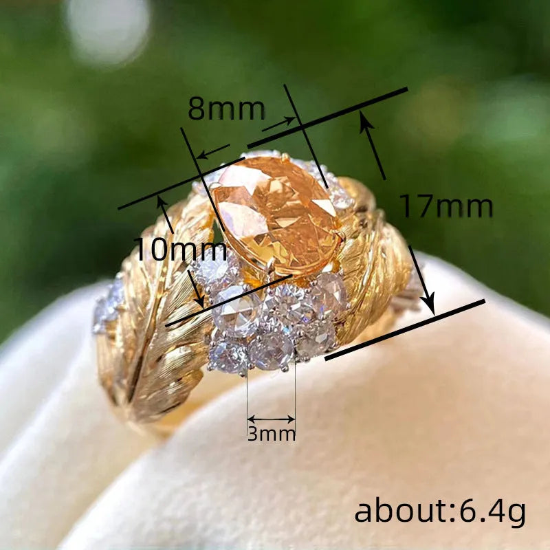 Gold-coloured copper ring with embossed feather pattern and yellow zircon stone.