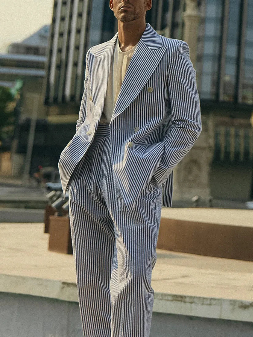 Blue and white striped men's polyester suit set with blazer and trousers on a model.