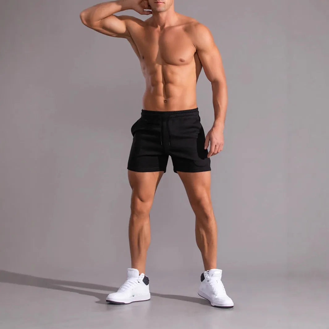 Three pairs of men's solid colour shorts with elastic drawstring waists in black, khaki and light brown