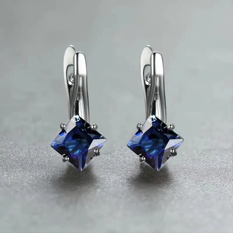 Women's copper earrings with inlaid zircon stones in a diamond design, colour option blue, on a white background