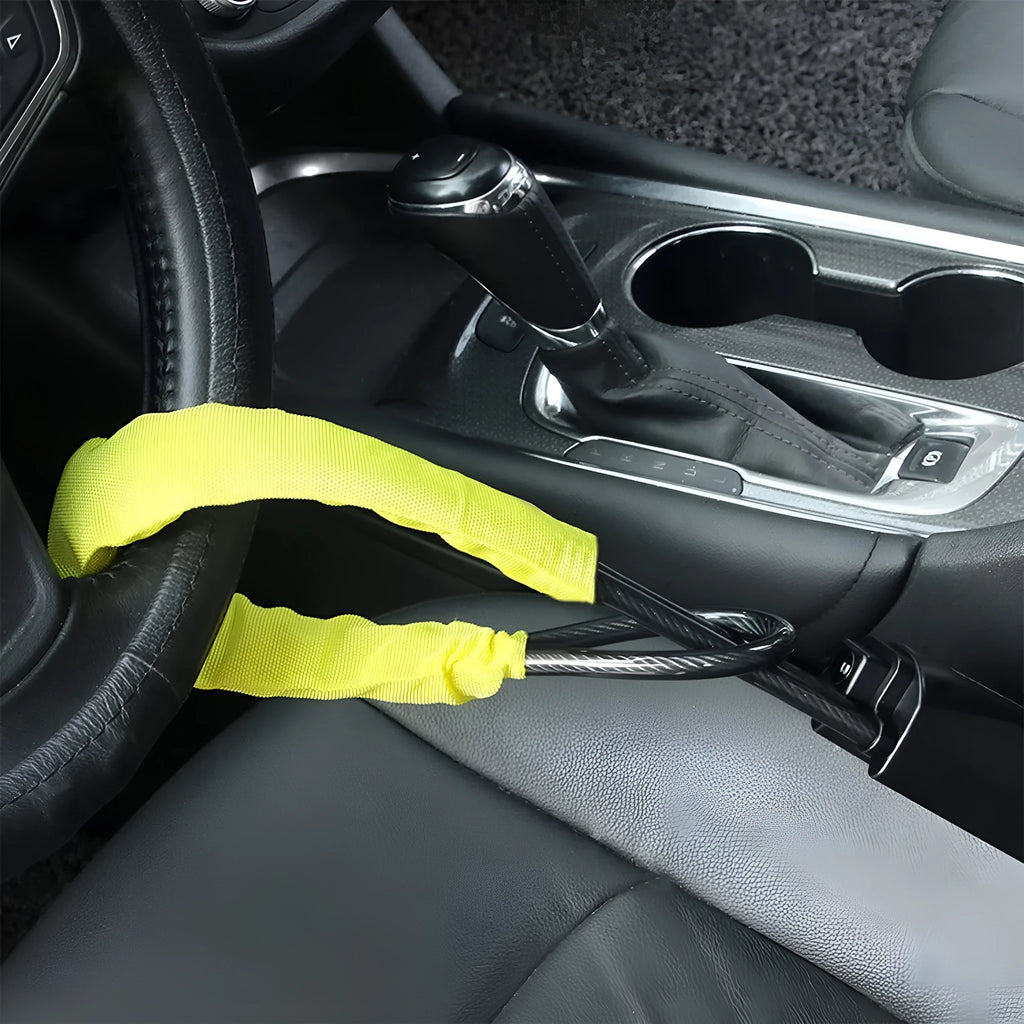 Red steel car steering wheel security lock with coiled cable on a car seat.