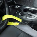 Red steel car steering wheel security lock with coiled cable on a car seat.