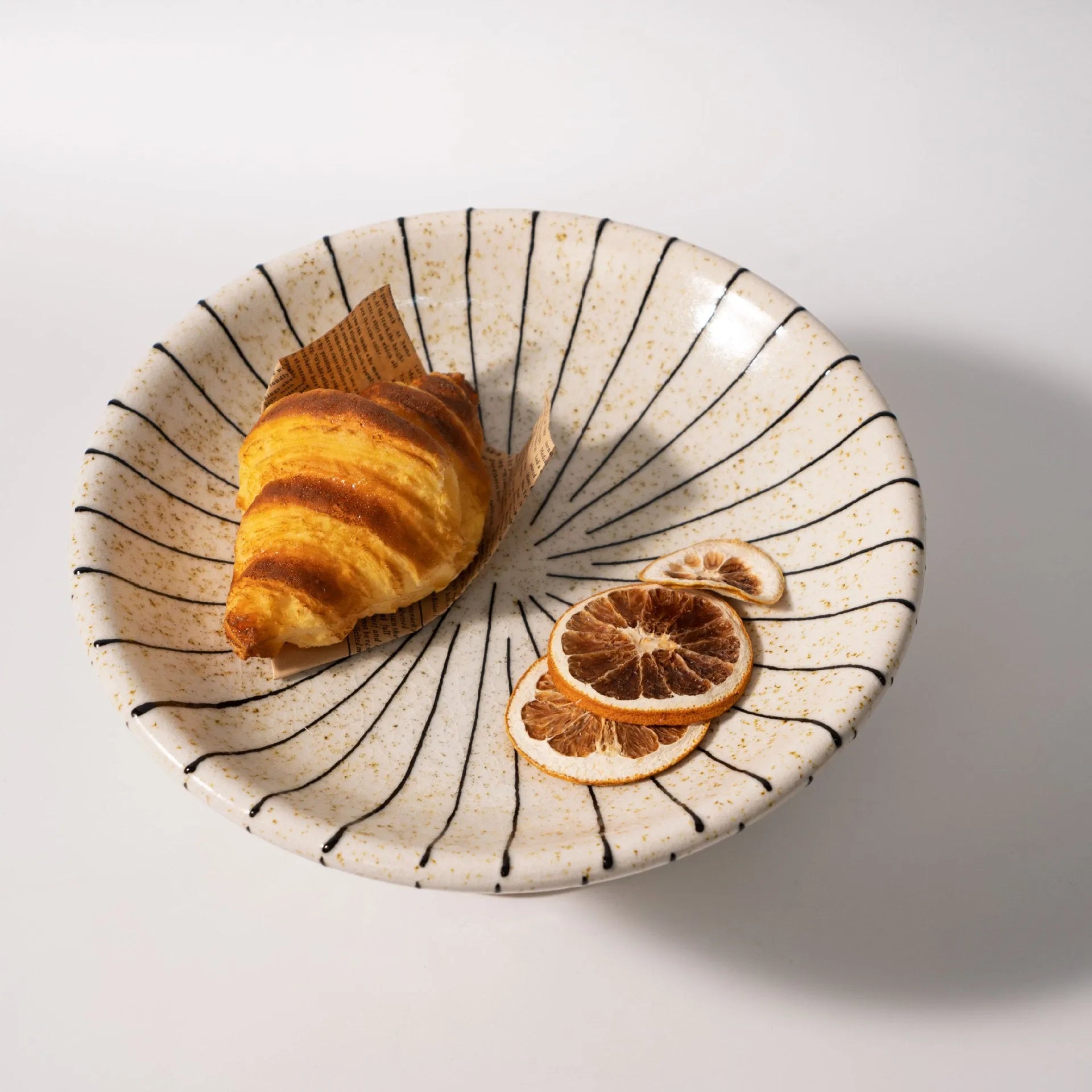 Black and white striped synthetic resin fruit plate on a table