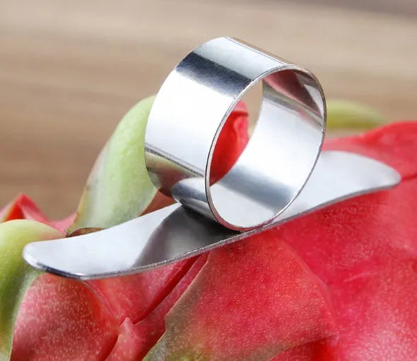 Silver stainless steel kitchen peeler tool with a finger ring for peeling oranges and citrus fruit.