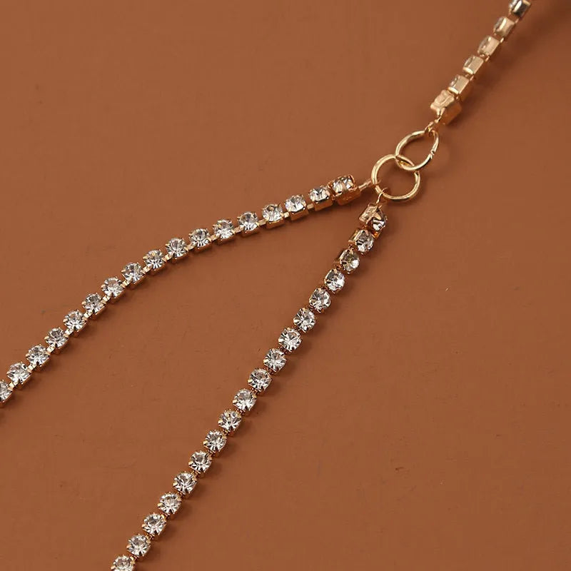 Women's white pearl multi-layer geometric body chain anklet on a light background