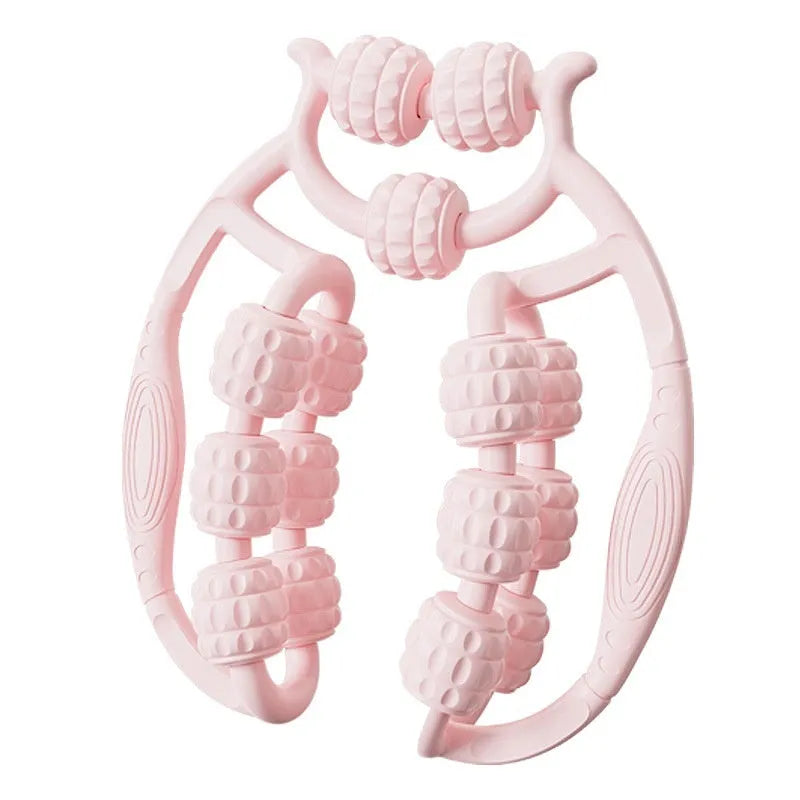A small, handheld leg massage roller with double-row wheels in coral pink, shown on a table.