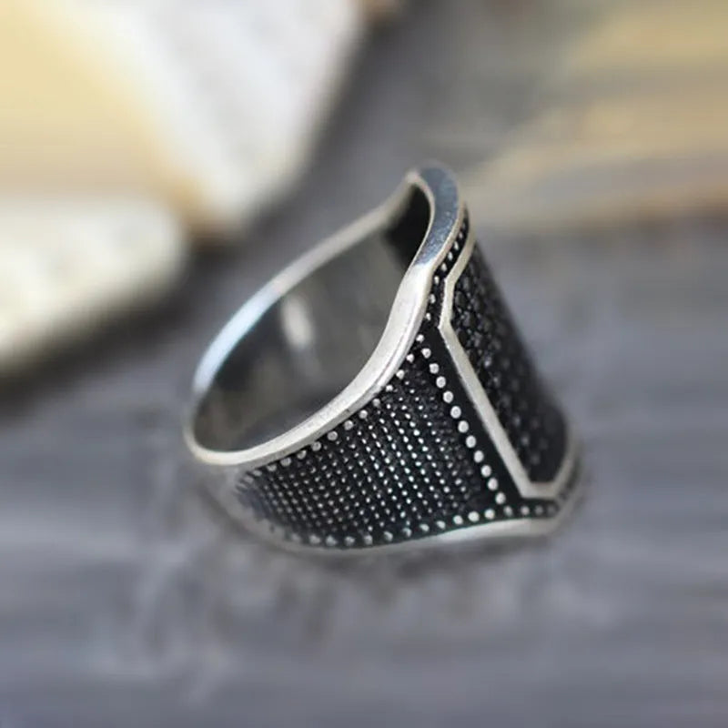 Black alloy fashion ring with a central zircon stone and copper metal inlays on a dark band.