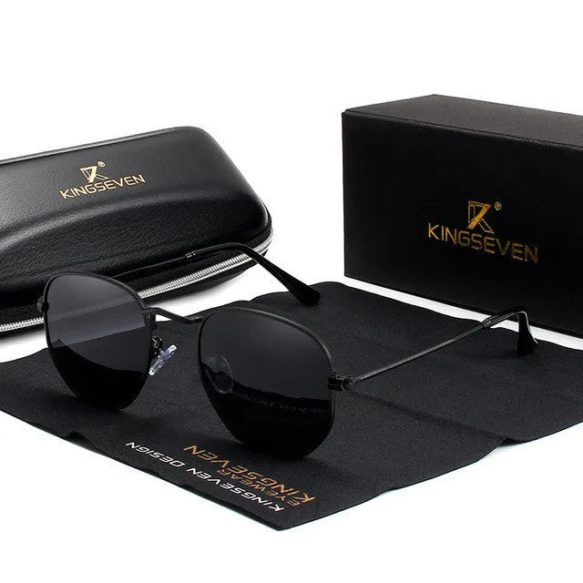 Classic round metal frame sunglasses for men in gun grey colour with UV400 lenses on a table.