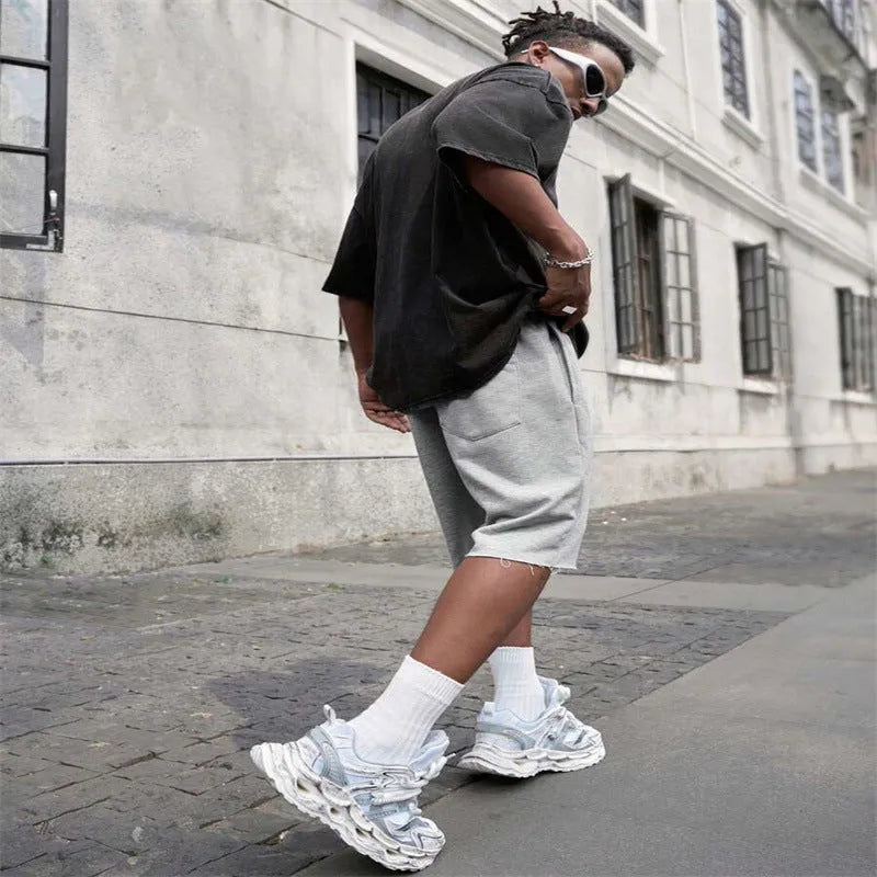 Men's straight-leg track trousers in black, shown in a casual streetwear style.