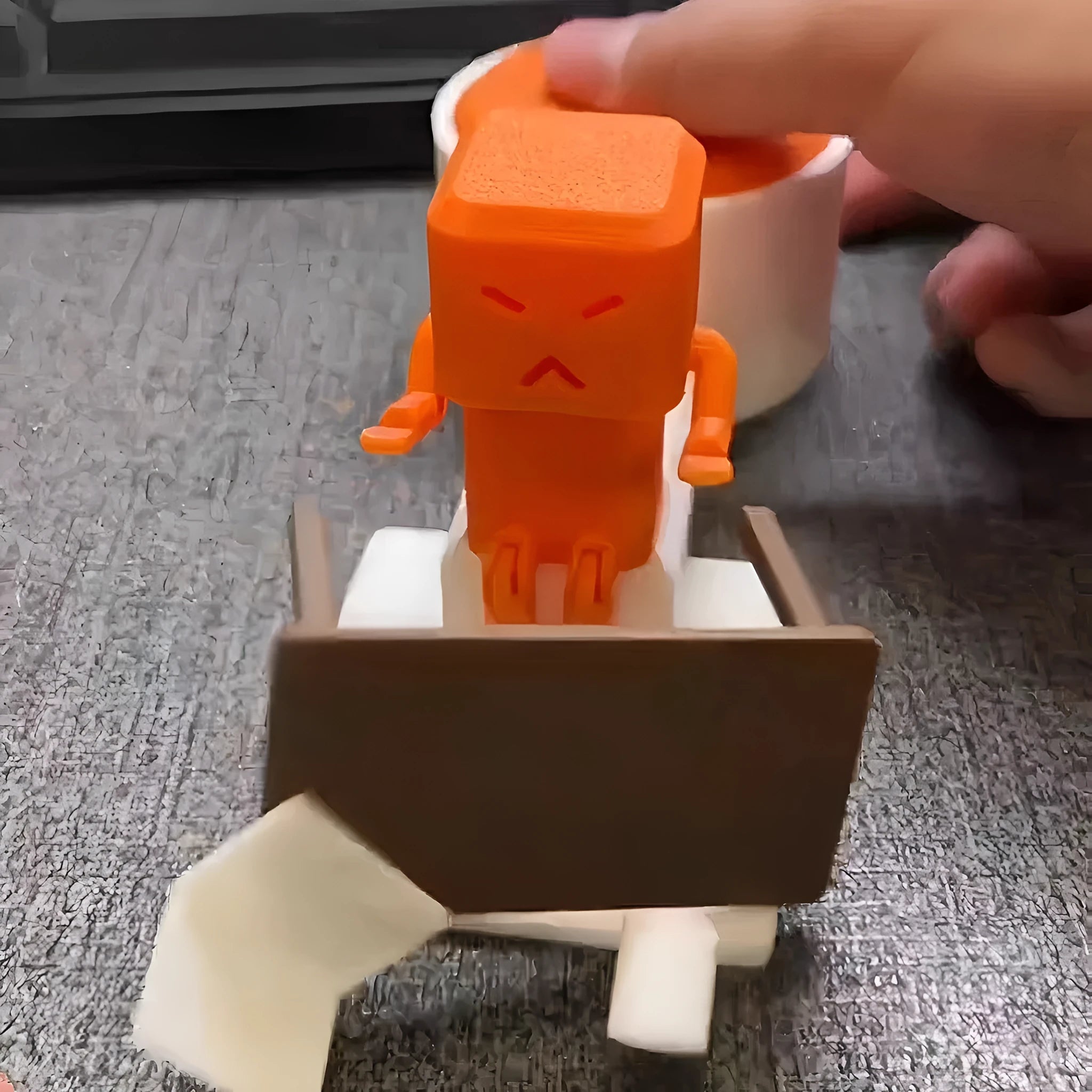 Orange plastic vent decompression artefact, a table turning fidget toy measuring 16x6x7 cm.