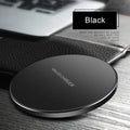 Ultra-thin black aluminium QI wireless charger with USB cable on wooden surface
