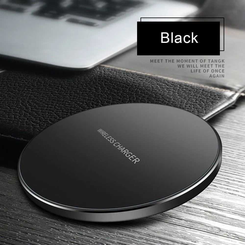 Ultra-thin black aluminium QI wireless charger with USB cable on wooden surface