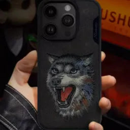 Red embroidered lion design TPU mobile phone case for iPhone 15 Pro Max on a surface