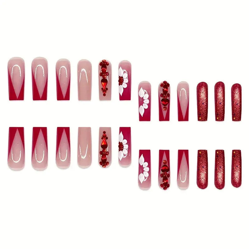 Long almond-shaped false nails with red diamond and floral art in sweet style.