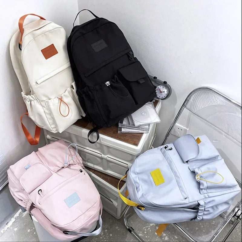 Nylon backpack school bag for junior high students, large capacity 20-35L, waterproof, with computer pocket, available in black.