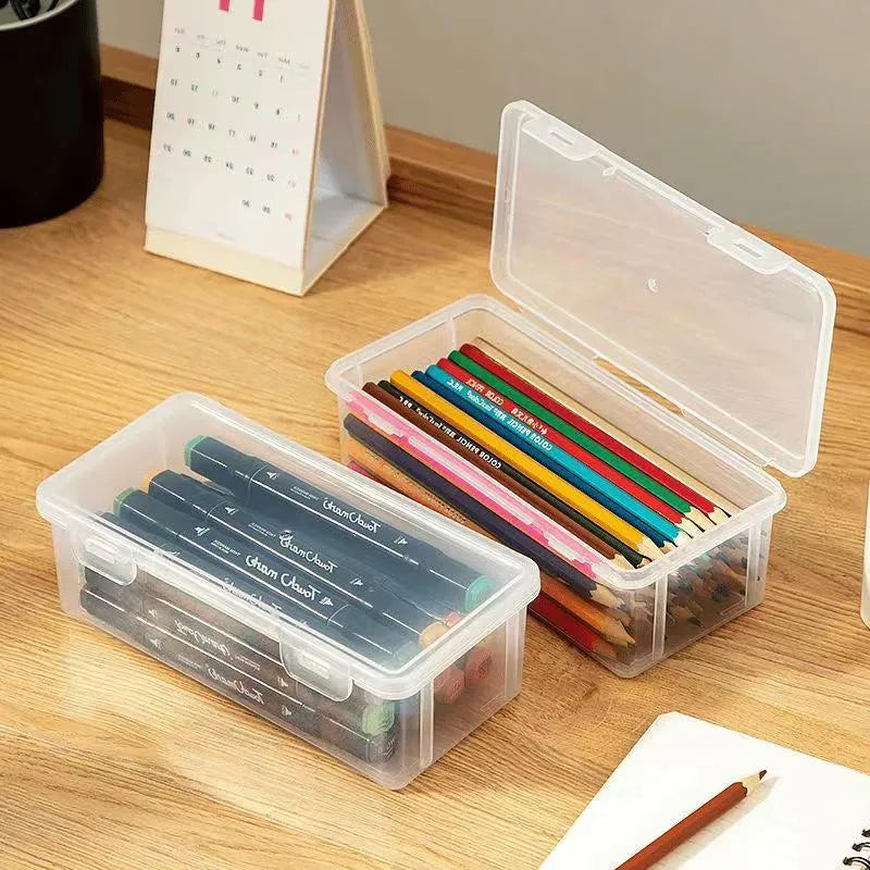 Clear transparent plastic storage box filled with coloured pencils and crayons with lid open.