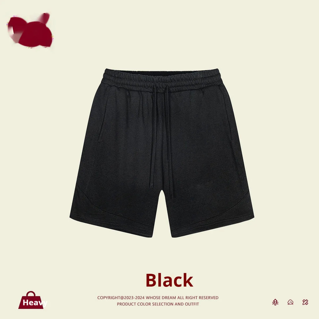 Child wearing solid colour loose cotton sports shorts in a neutral shade.