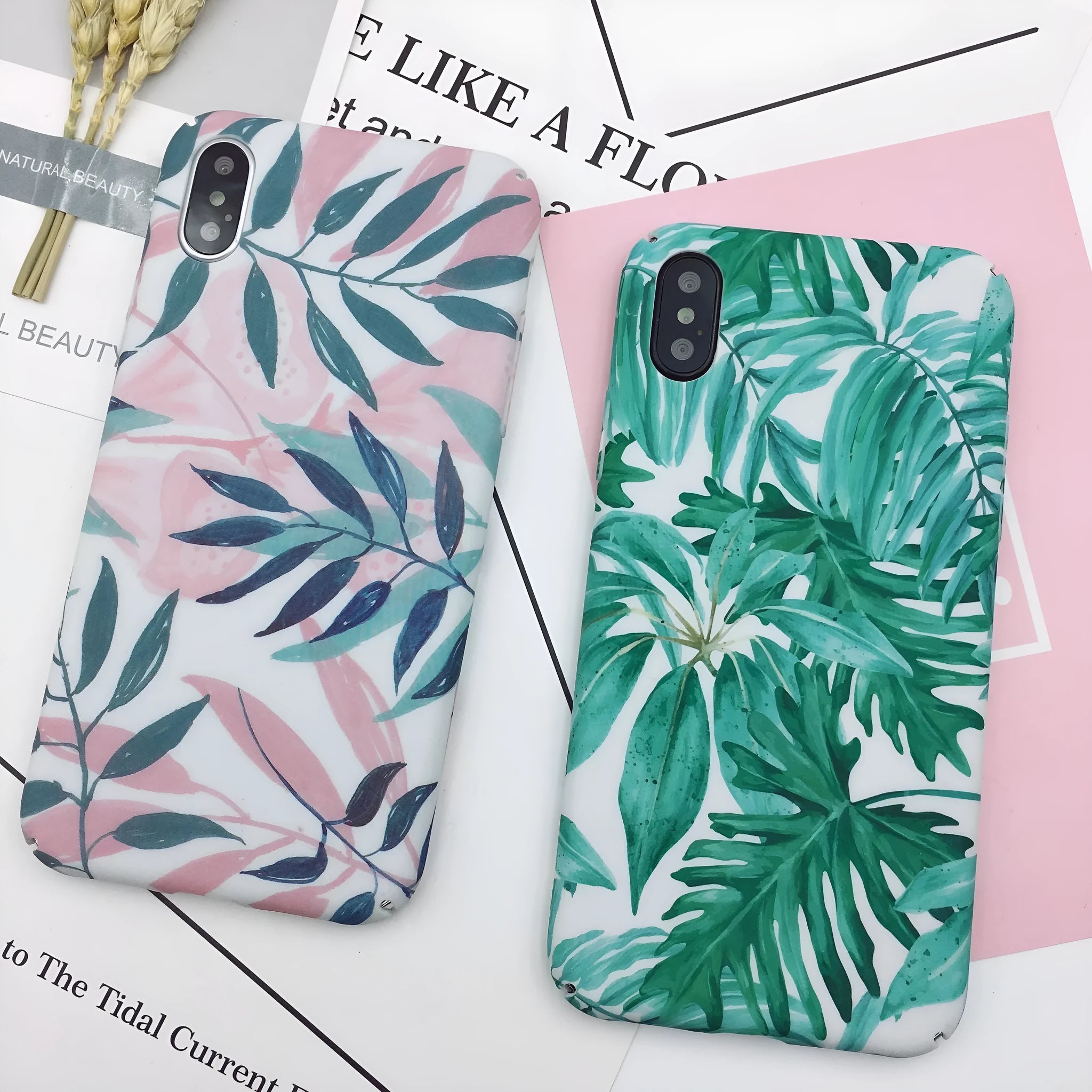Green and pink painted plastic back cover cases for mobile phones on a white background.