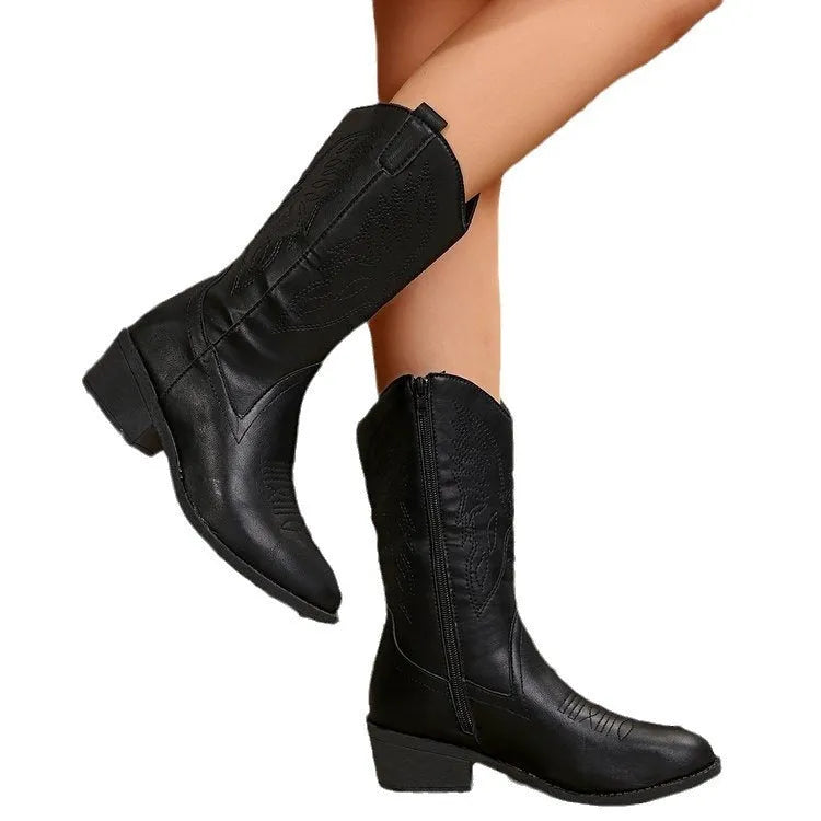Women's black mid-calf Martin boots with a pointed chunky heel and hollow-out design on a white background.