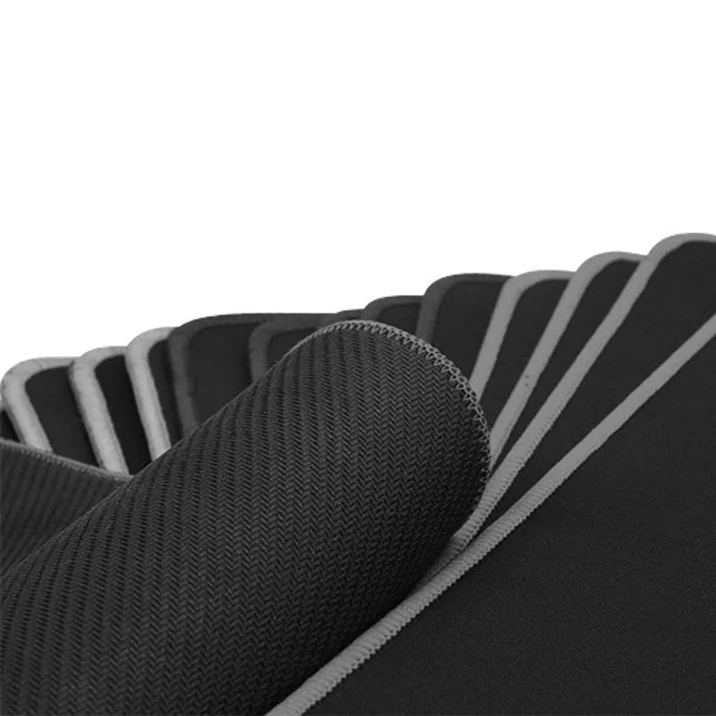 All black extra long desk mat with overlock stitched edges on a wooden desk
