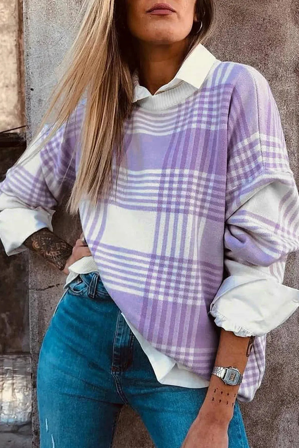 Lilac plaid print loose-fitting long sleeve sweater with ribbed trim on a hanger.