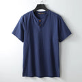 A loose-fitting apricot coloured cotton V-neck short sleeve summer top laid flat.