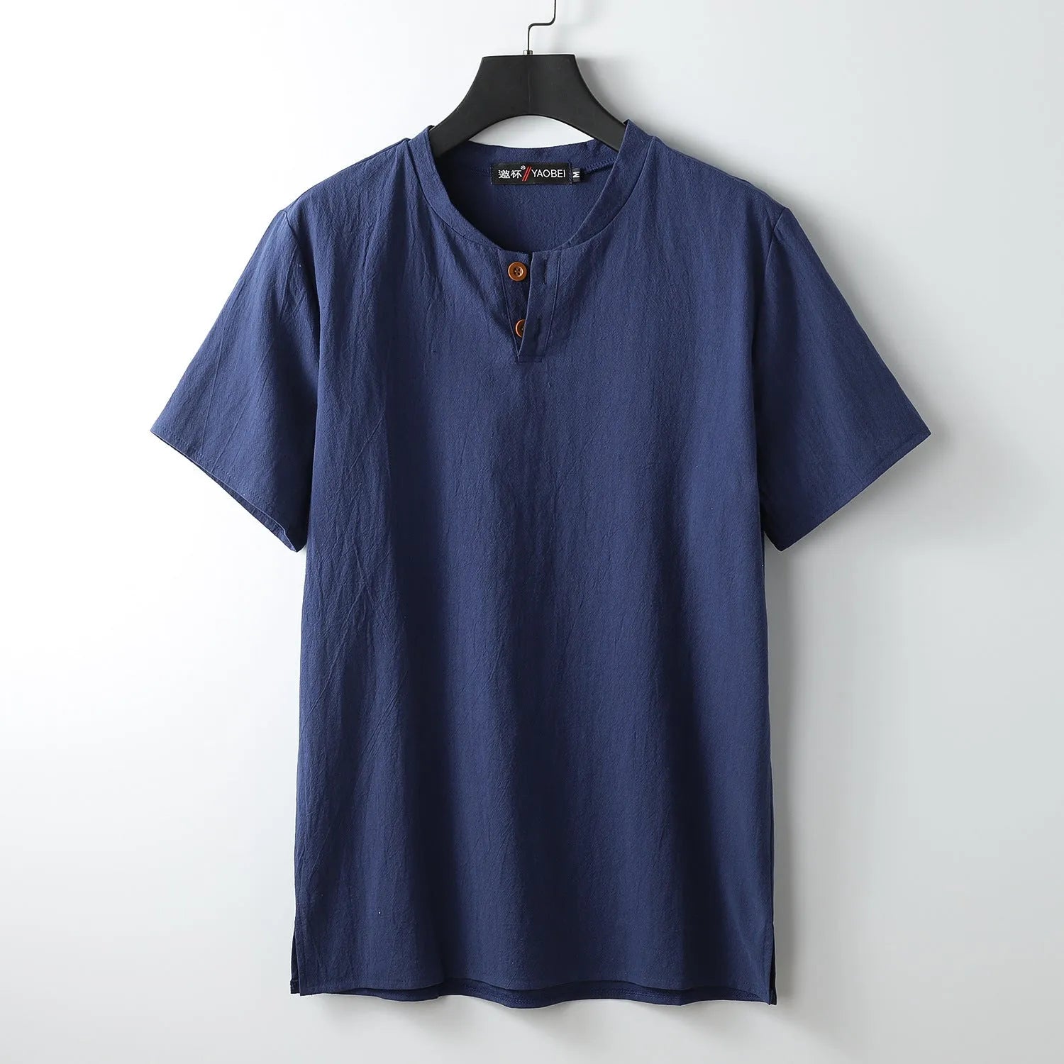 A loose-fitting apricot coloured cotton V-neck short sleeve summer top laid flat.