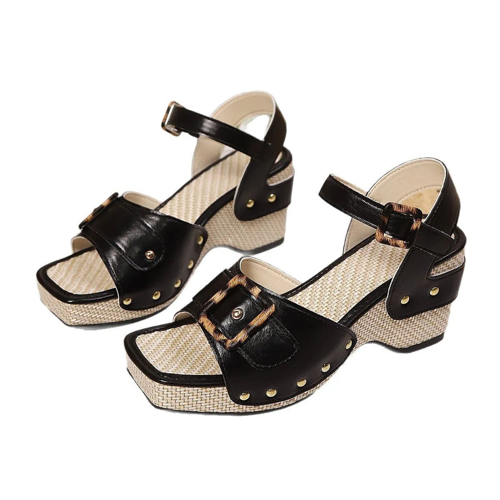 Women's black chunky heel sandals with a square toe and metal buckle fastening on a rubber sole.