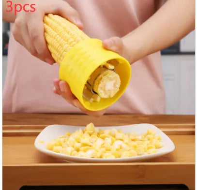 Yellow manual corn grinder thresher with corn-shaped design on a kitchen counter.