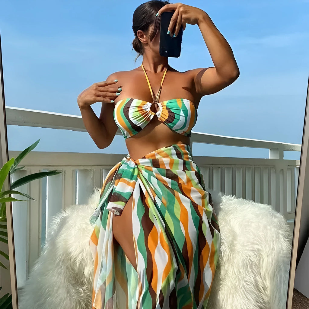 Women's yellow green three-piece bikini set with a beach skirt laid flat