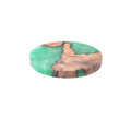 A solid black round resin coaster for a tea set, 9.8cm across and 1cm thick, on a wooden surface.