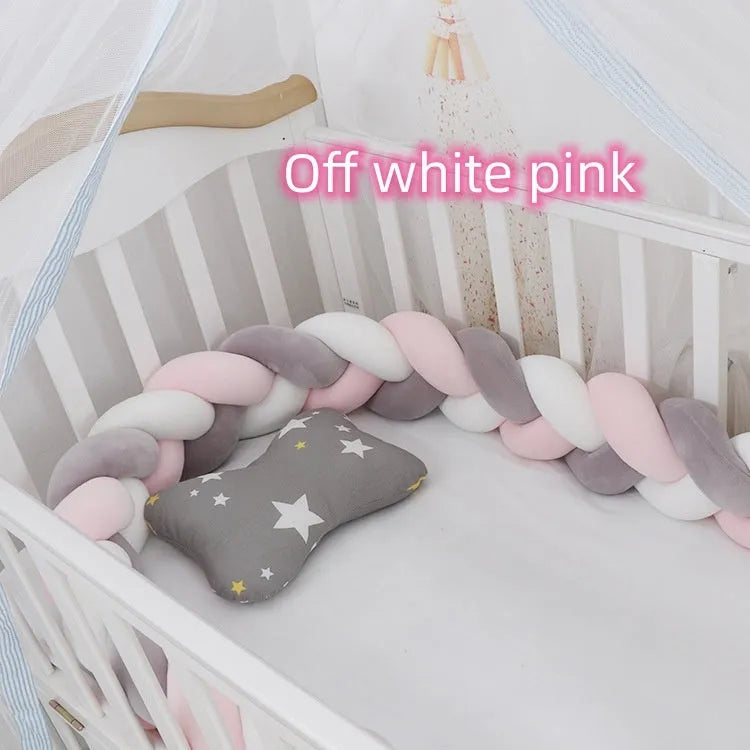Braided knot style crib bumper in spandex velvet, wrapped around white cot rails in a nursery.