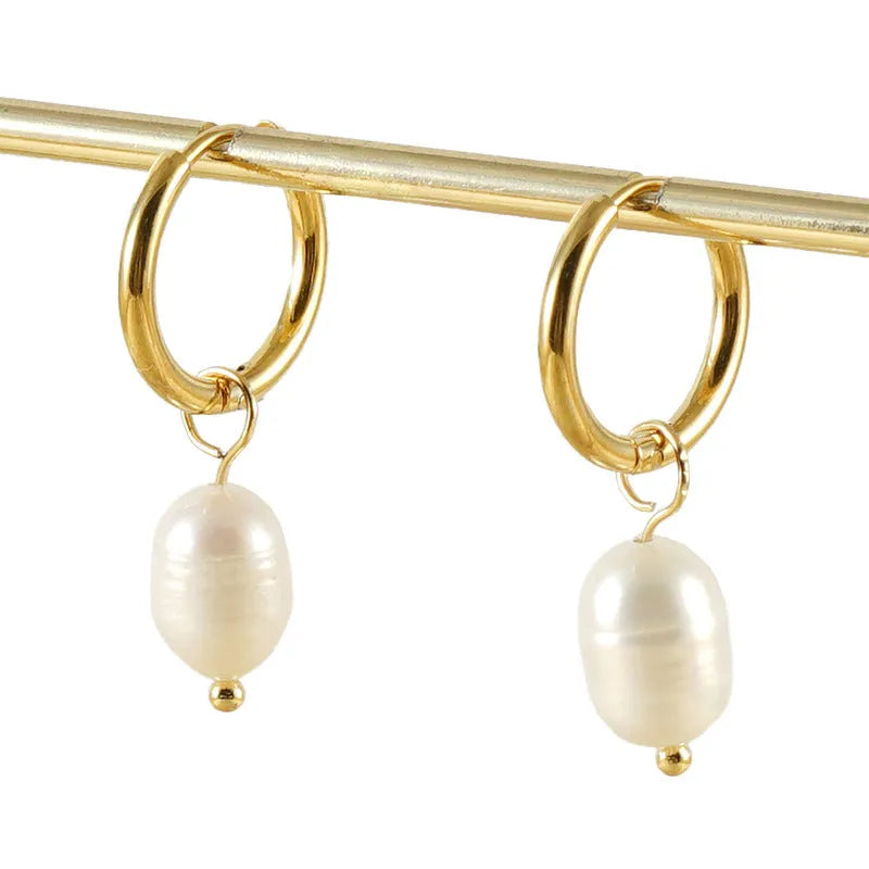 A pair of gold geometric drop earrings featuring stainless steel construction and central freshwater pearls.