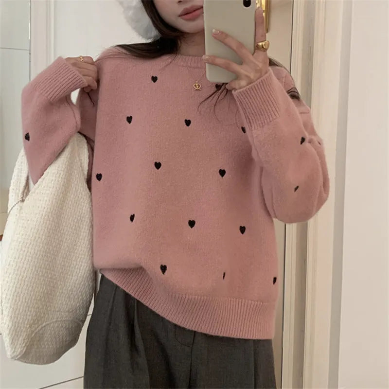 Women's loose grey acrylic pullover sweater with embroidery on the chest and long sleeves.