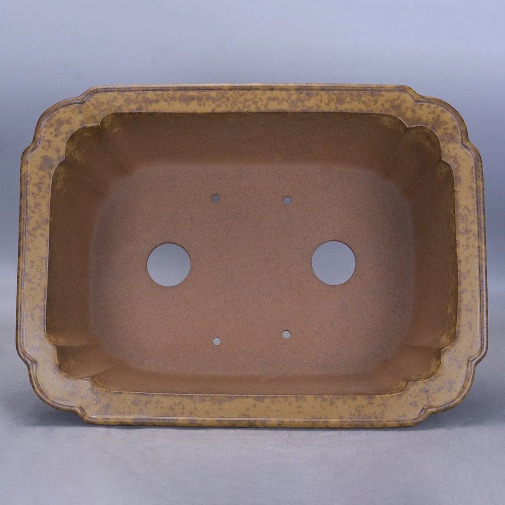 Large rectangular purple sand flowerpot with angled drainage base on a wooden patio.