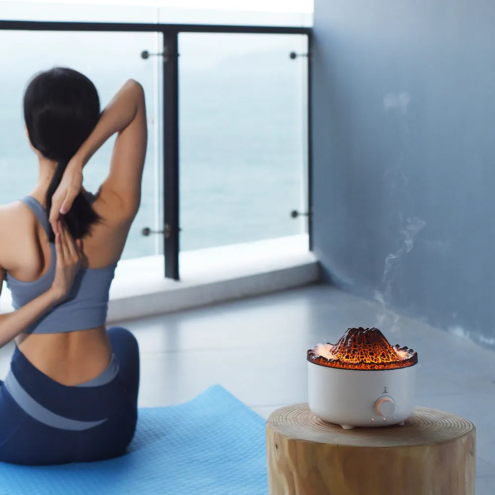 White simulated flame volcano humidifier and aroma diffuser with remote control on wooden surface