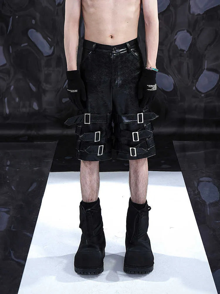 Men's black PU leather cropped pants with a ring detail on low-waist shorts.