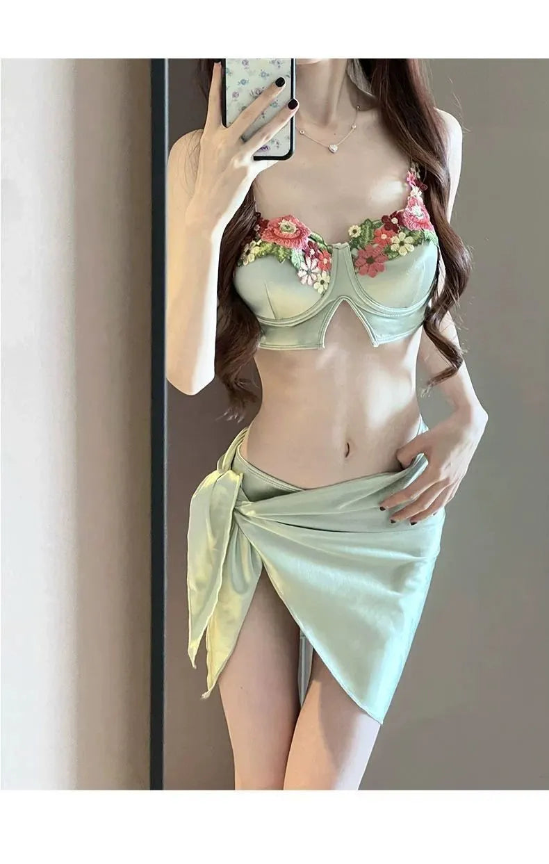 Green women's three-piece bikini set showing triangle top, briefs, and matching skirt on a white background.