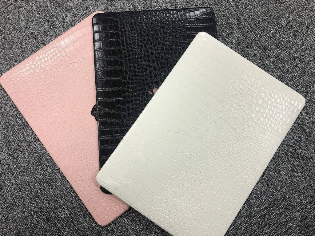 MacBook protective case with crocodile pattern texture and hollowed-out Apple logo in black, white, or soft pink