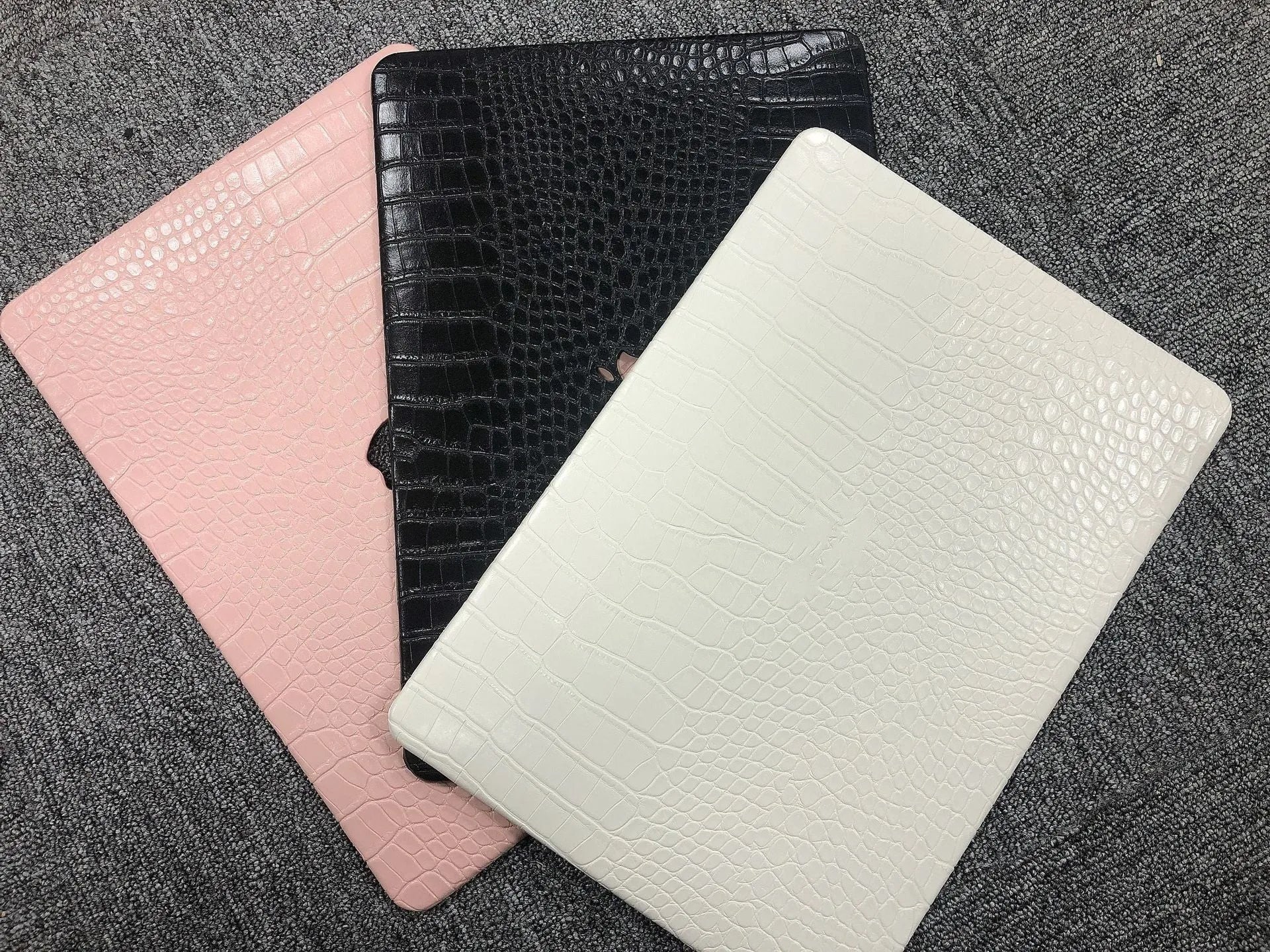 MacBook protective case with crocodile pattern texture and hollowed-out Apple logo in black, white, or soft pink