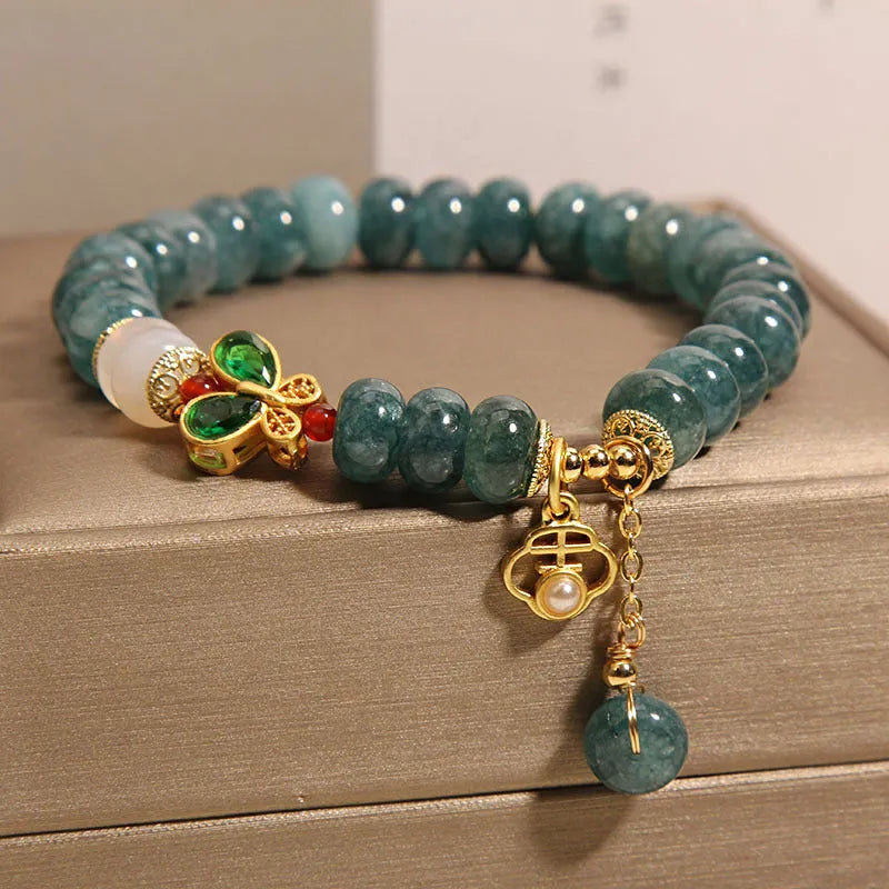 Blue water jade and white agate abacus bead bracelet with alloy inlay, rhinestones, and butterfly charm.