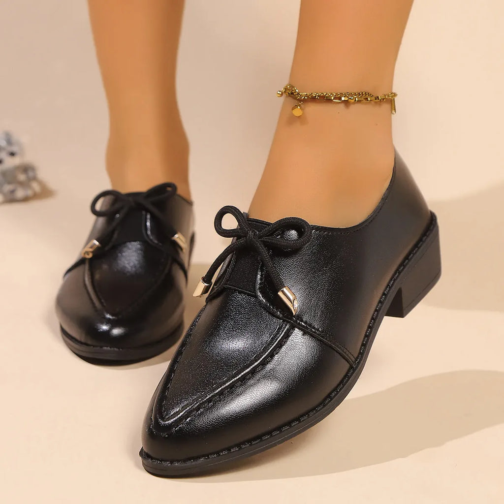 Women's simple leather-look shoes with a decorative bow, on a rubber sole.