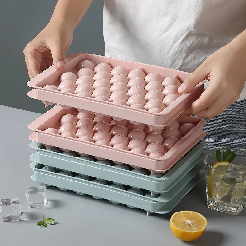 Round ball ice cube moulds in sky blue and pink creating spherical ice for drinks